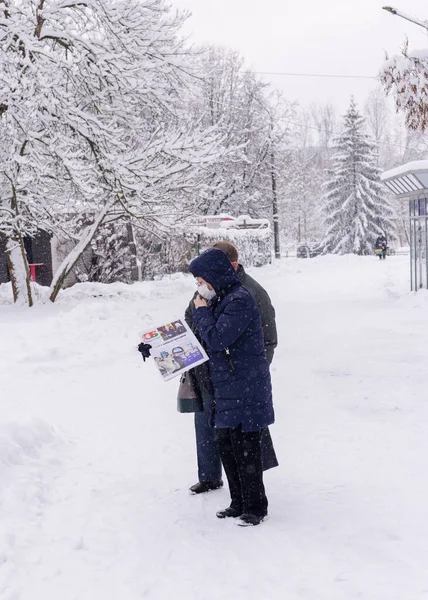 Vrouw en man kijken krant terwijl staan op de straat — Stockfoto