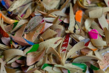 Beyaz arka planda renkli kalemlerin talaşları. Makro çekim.