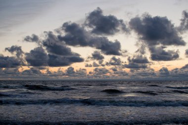Bulutlu ve dalgalı akşam deniz manzarası. Dramatik Deniz Burnu.