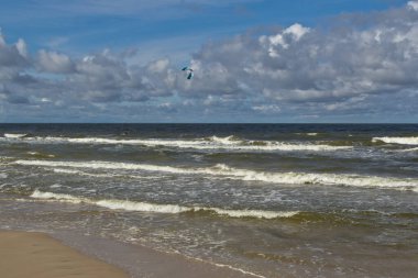 Gün boyunca sahil. Bulutlar ve deniz dalgaları.