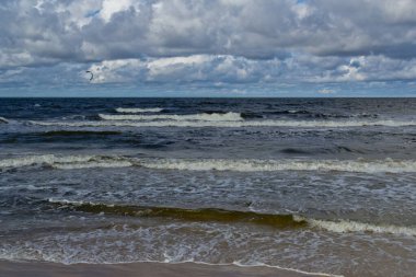 Gün boyunca sahil. Bulutlar ve deniz dalgaları.