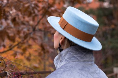 Sırtında mavi şapkalı bir kadın.