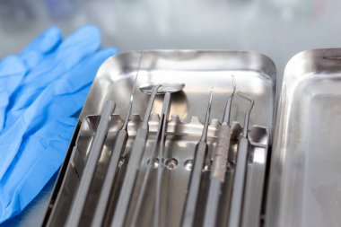 Diş aletleri ve tıbbi eldivenler masada.