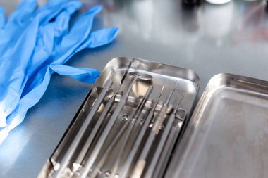 Diş aletleri ve tıbbi eldivenler masada.