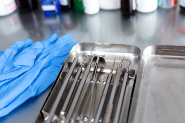 Diş aletleri ve tıbbi eldivenler masada.