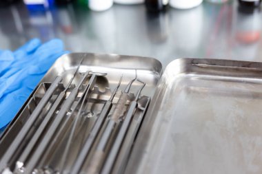 Diş aletleri ve tıbbi eldivenler masada.