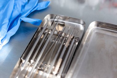 Diş aletleri ve tıbbi eldivenler masada.