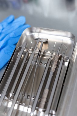 Diş aletleri ve tıbbi eldivenler masada.