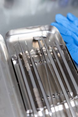 Diş aletleri ve tıbbi eldivenler masada.