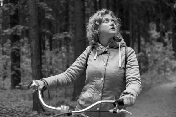 Mujer rubia con bicicleta en el bosque. Negro y whait foto. — Foto de Stock