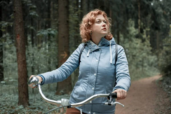 Femme blonde avec vélo dans les bois. — Photo