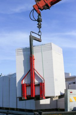 Vinç kullanarak bir kamyondan yapı taşlarını indiriyorum. Hidrolik düzenleyici.