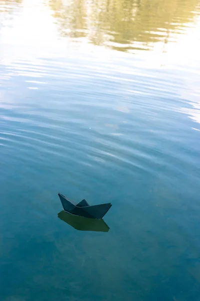 Barco de papel negro flota en el río — Foto de Stock