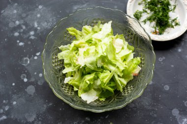 Gri masadaki cam kasede salata.