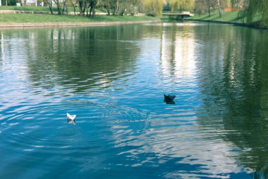 Siyah beyaz kağıt kayıklar suda yüzer.