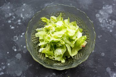 Gri masadaki cam kasede salata.