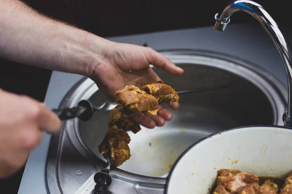 Кухар нанизує м'ясо на шампури для приготування їжі — стокове фото