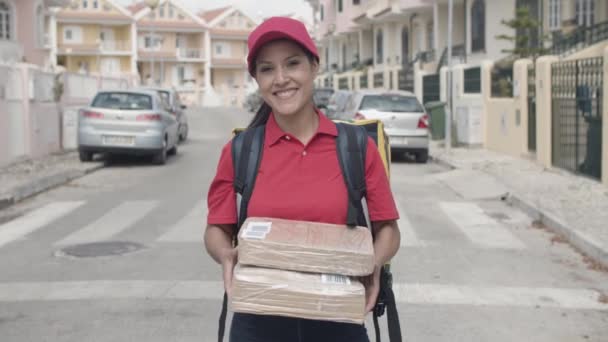 Menina correio feliz com mochila térmica segurando pacotes — Vídeo de Stock