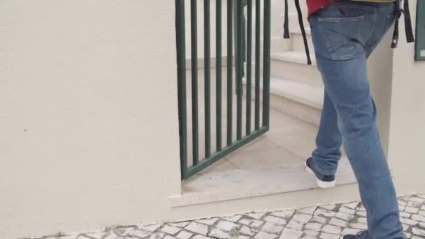 Deliveryman opening gates, leaving packages on customers stairs — Stock Video