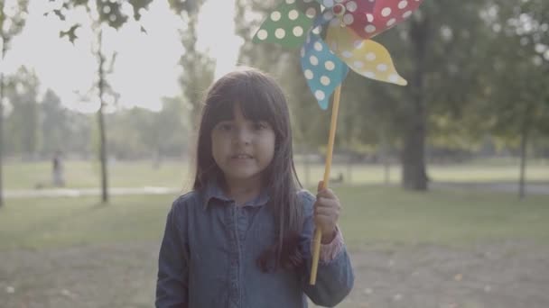 Χαριτωμένο Λατίνο κορίτσι κρατώντας ανεμιστήρα χαρτί, μιλάμε, θέτουν και στέκεται — Αρχείο Βίντεο