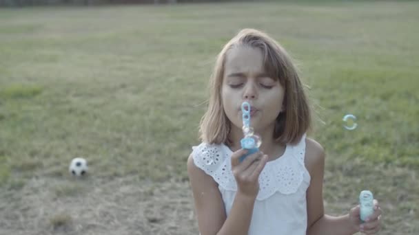 Εστιασμένη Καυκάσια κοπέλα φυσάει φυσαλίδες με κλειστά μάτια — Αρχείο Βίντεο