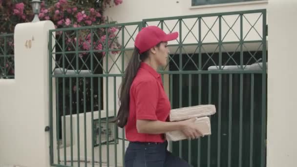 Teslimatçı kız müşteri kapısına doğru yürüyor. — Stok video