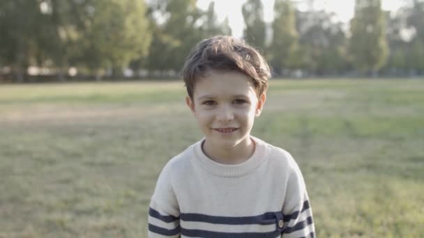Πορτρέτο του όμορφου Καυκάσιου αγοριού χαμογελώντας και πηδώντας στην κάμερα — Αρχείο Βίντεο