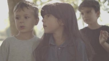 Sevimli kız ve erkek yan yana durur ve bir şeye bakarlar.