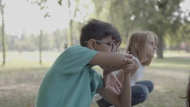 Leuke jongen in bril wrijven neus met elleboog — Stockvideo