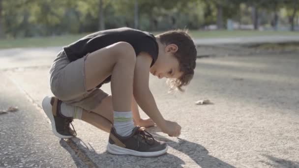 Geconcentreerde blanke jongen schilderen met krijt op asfalt — Stockvideo