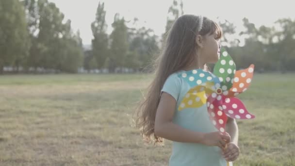 Sorrindo menina latina segurando ventilador de papel brilhante e de pé — Vídeo de Stock