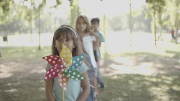 Chicas felices sosteniendo ventiladores de papel y caminando — Vídeos de Stock