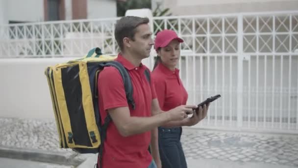 Twee bezorgers die naar buiten lopen — Stockvideo