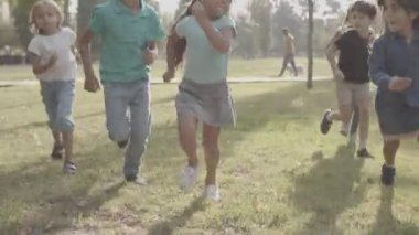 Mutlu çocukların birlikte koşması ve gülümsemesi.