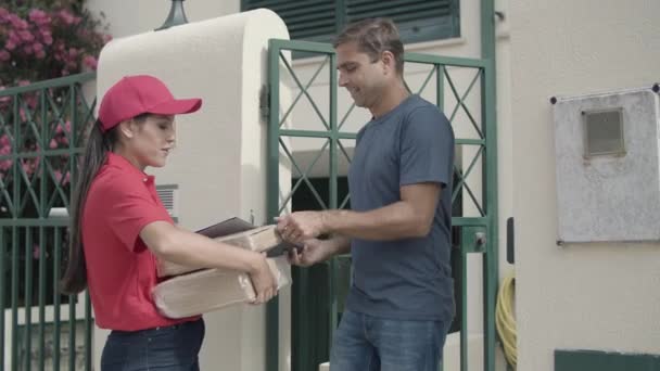 Chica mensajera positiva en paquete de entrega roja — Vídeo de stock