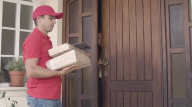 Kırmızılı erkek kurye kapıyı çalıyor.