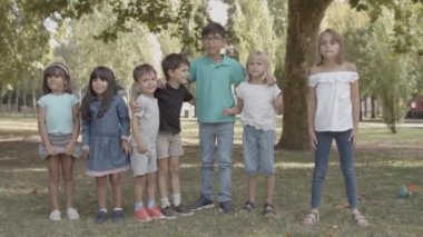 Coşkulu çoklu etnik çocuklar çömelmiş ve ayakta