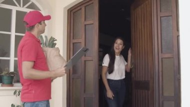 Kırmızı üniformalı kurye kapıyı çalıyor.