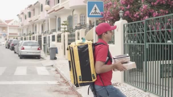 Entregador cruzando la calle y trayendo paquetes a los clientes — Vídeos de Stock