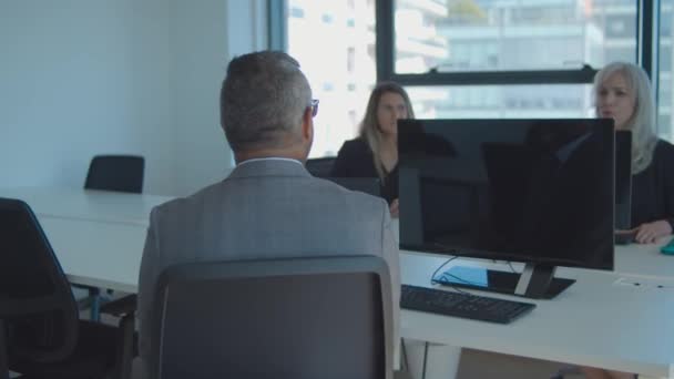 Colegas sentados en la mesa de reuniones con computadoras — Vídeo de stock