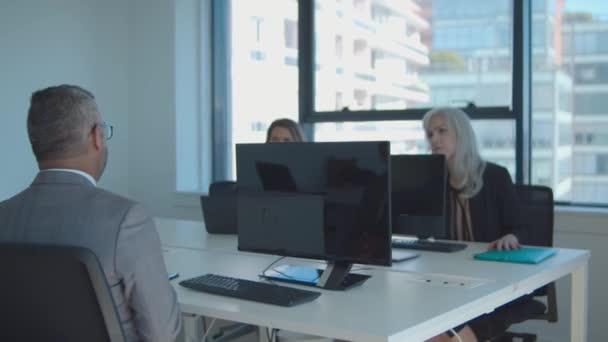 Zakelijke collega 's zitten samen aan vergadertafel — Stockvideo