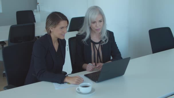 Zwei seriöse Geschäftsfrauen benutzen Laptop für Videogespräche — Stockvideo