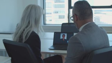 Birkaç meslektaşım video konuşması için dizüstü bilgisayar kullanıyor.