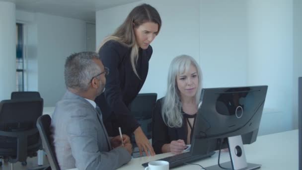 Collega 's kijken en discussiëren over presentatie op monitor — Stockvideo