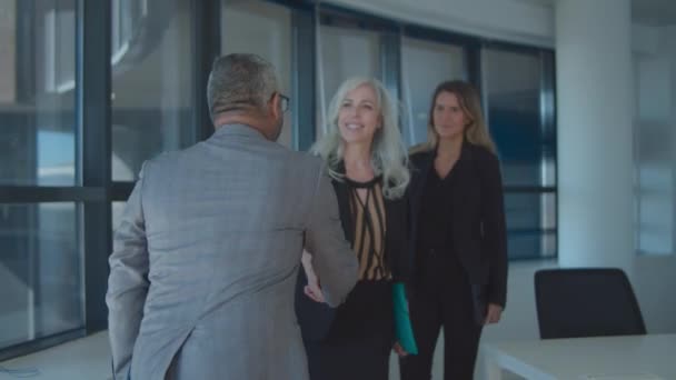 Självsäker affärsman möter kvinnliga partners på sitt kontor — Stockvideo
