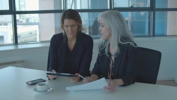 Позитивные женщины-менеджеры обсуждают и анализируют отчеты — стоковое видео