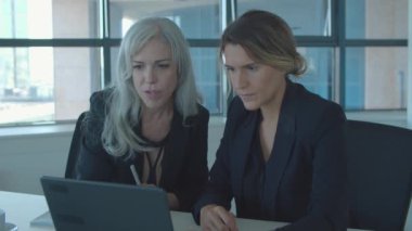 Birlikte dizüstü bilgisayar kullanan pozitif kadın çalışanlar.