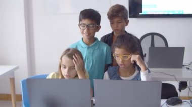 Masada oturan ve ayakta duran odaklanmış öğrencilerden oluşan bir takım.