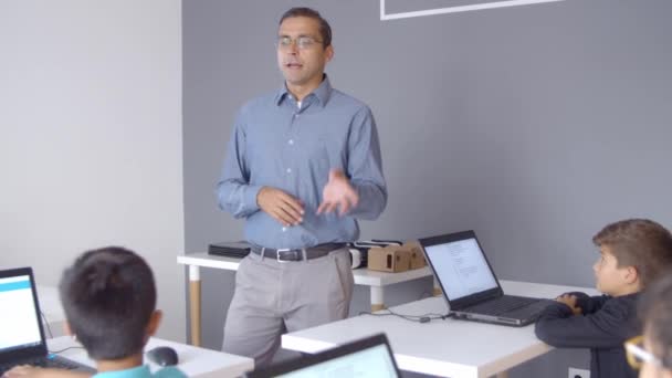 Computer science teacher speaking before children — Stock Video