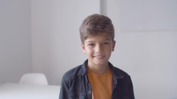 Happy Caucasian boy standing in classroom — Stock Video